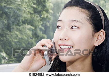 headshot of young japanese girl talking on mobile phone View Large Photo Image Stock Image - headshot of young japanese girl talking on mobile phone. Fotosearch