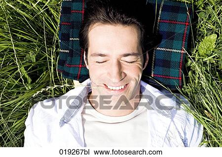 headshot of young man lying in grass View Large Photo Image Stock Image - headshot of young man lying in grass. Fotosearch