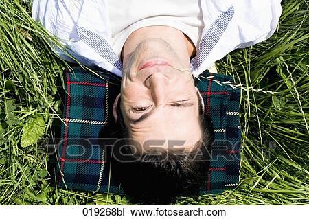 headshot of young man lying in grass View Large Photo Image Stock Image - headshot of young man lying in grass. Fotosearch