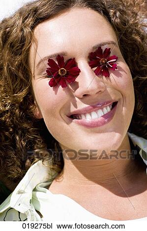 headshot of young woman with red flowers on her eyes View Large Photo Image Stock Image - headshot of young woman with red flowers on her eyes. Fotosearch