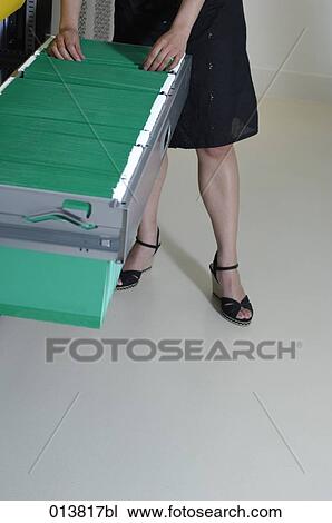legs of woman looking through files in filing cabinet View Large Photo Image Stock Image - legs of woman looking through files in filing cabinet. Fotosearch