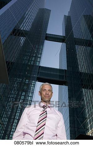 Stock Image - low angle portrait of mature businessman in front of office building. Fotosearch