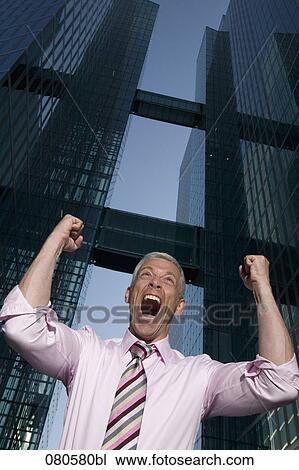 low angle portrait of mature businessman in front of office building celebrating View Large Photo Image Stock Image - low angle portrait of mature businessman in front of office building celebrating. Fotosearch