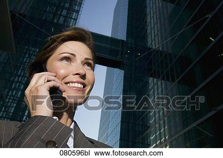 low angle portrait of mature businesswoman talking on mobile phone in front of office building View Large Photo Image Stock Image - low angle portrait of mature businesswoman talking on mobile phone in front of office building. Fotosearch