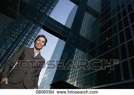 Stock Image - low angle portrait of mature businesswoman in front of office building. Fotosearch