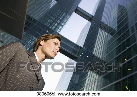 Stock Image - low angle portrait of mature businesswoman in front of office building. Fotosearch