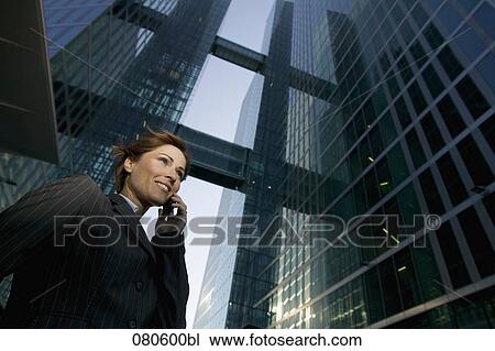 low angle view of mature businesswoman talking on mobile phone in front of office building View Large Photo Image Stock Image - low angle view of mature businesswoman talking on mobile phone in front of office building. Fotosearch