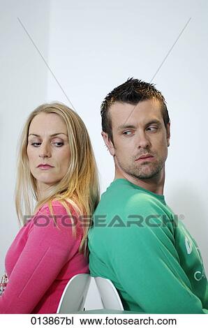 man and woman sitting back to back suspiciously looking at each other View Large Photo Image Stock Image - man and woman sitting back to back suspiciously looking at each other. Fotosearch