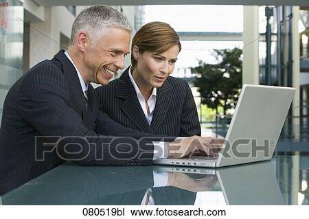 mature businessman and businesswoman working together with laptop computer View Large Photo Image Stock Image - mature businessman and businesswoman working together with laptop computer. Fotosearch