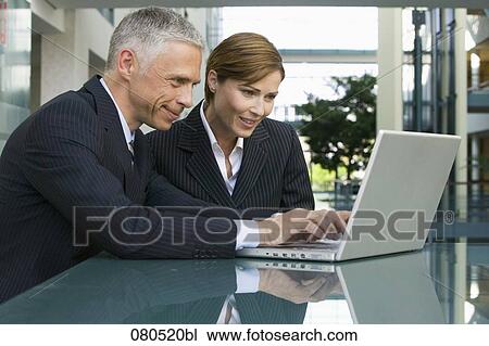 mature businessman and businesswoman working together with laptop computer View Large Photo Image Stock Image - mature businessman and businesswoman working together with laptop computer. Fotosearch