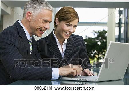 mature businessman and businesswoman working together with laptop computer View Large Photo Image Stock Image - mature businessman and businesswoman working together with laptop computer. Fotosearch