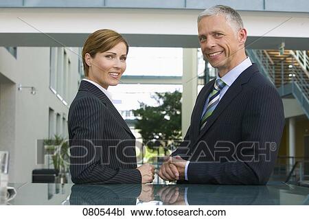 mature businesswoman and male colleague having conversation in office lobby View Large Photo Image Stock Image - mature businesswoman and male colleague having conversation in office lobby. Fotosearch