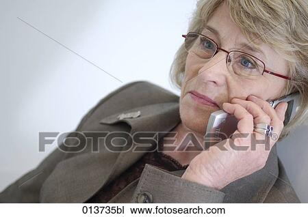 mature businesswoman talking on mobile phone looking concerned View Large Photo Image Stock Image - mature businesswoman talking on mobile phone looking concerned. Fotosearch