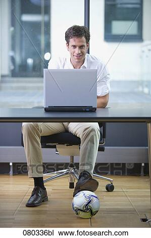 office worker working with laptop computer having football under the table View Large Photo Image Stock Image - office worker working with laptop computer having football under the table. Fotosearch