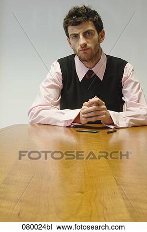 portrait of annoyed businessman sitting at conference table View Large Photo Image Stock Image - portrait of annoyed businessman sitting at conference table. Fotosearch