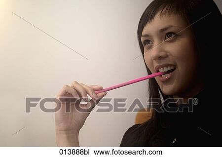 portrait of asian businesswoman biting on her pencil View Large Photo Image Stock Image - portrait of asian businesswoman biting on her pencil. Fotosearch