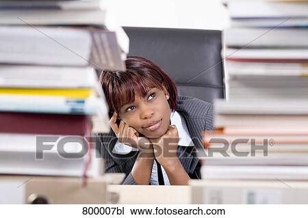 portrait of black businesswoman sitting behind piles of paper View Large Photo Image Stock Image - portrait of black businesswoman sitting behind piles of paper. Fotosearch