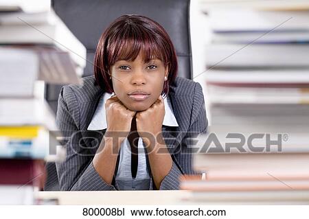 portrait of black businesswoman sitting behind piles of paper View Large Photo Image Stock Image - portrait of black businesswoman sitting behind piles of paper. Fotosearch
