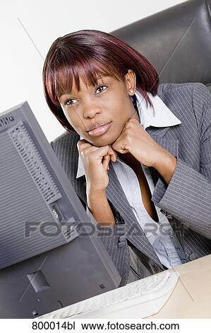 portrait of black businesswoman sitting at desk day-dreaming View Large Photo Image Stock Image - portrait of black businesswoman sitting at desk day-dreaming. Fotosearch