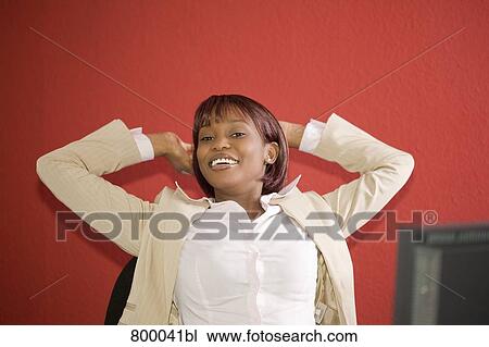 portrait of black businesswoman sitting at desk stretching herself View Large Photo Image Stock Image - portrait of black businesswoman sitting at desk stretching herself. Fotosearch