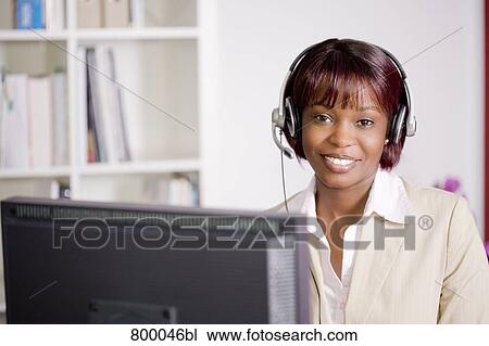 portrait of black businesswoman sitting behind computer wearing headset View Large Photo Image Stock Image - portrait of black businesswoman sitting behind computer wearing headset. Fotosearch