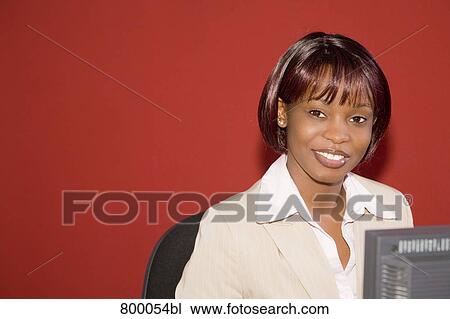 Stock Image - portrait of black businesswoman sitting behind computer. Fotosearch