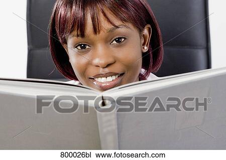 portrait of black woman hiding behind book View Large Photo Image Stock Image - portrait of black woman hiding behind book. Fotosearch