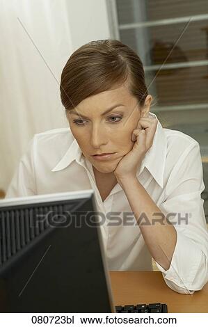 Stock Image - portrait of bored businesswoman looking at computer. Fotosearch