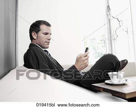 portrait of businessman checking his mobile phone for text messages View Large Photo Image Stock Image - portrait of businessman checking his mobile phone for text messages. Fotosearch