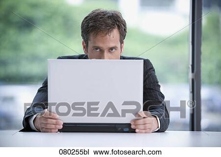 portrait of businessman hiding behind laptop computer View Large Photo Image Stock Image - portrait of businessman hiding behind laptop computer. Fotosearch