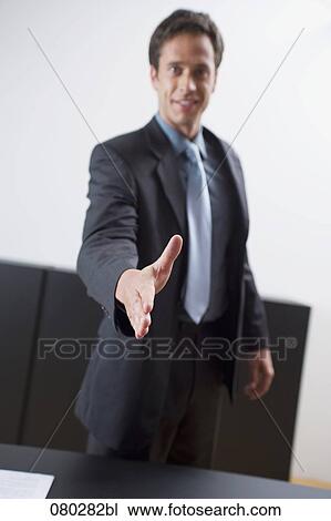 Stock Image - portrait of businessman reaching out his hand for welcome. Fotosearch