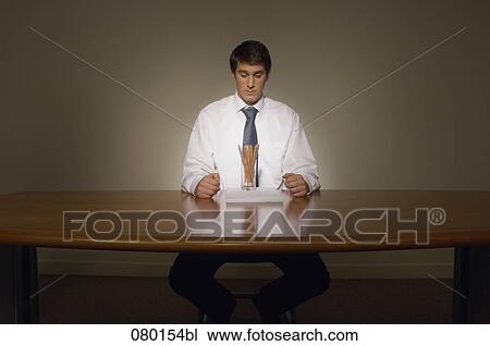 portrait of businessman sitting at desk with papers and pencils View Large Photo Image Stock Image - portrait of businessman sitting at desk with papers and pencils. Fotosearch