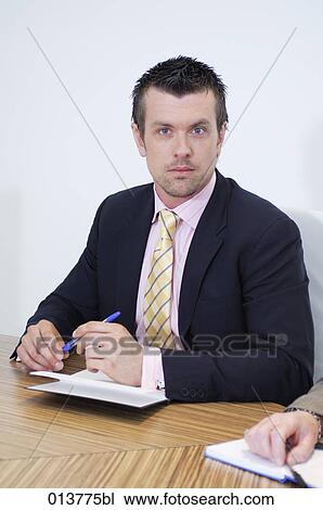 Stock Image - portrait of businessman sitting in meeting. Fotosearch