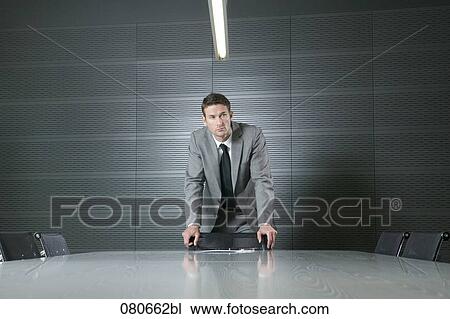 portrait of businessman standing at conference table in meeting room View Large Photo Image Stock Image - portrait of businessman standing at conference table in meeting room. Fotosearch