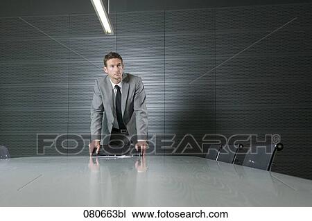 portrait of businessman standing at conference table in meeting room View Large Photo Image Stock Image - portrait of businessman standing at conference table in meeting room. Fotosearch