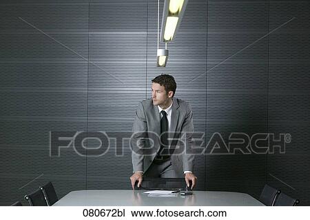 portrait of businessman standing at conference table in meeting room View Large Photo Image Stock Image - portrait of businessman standing at conference table in meeting room. Fotosearch