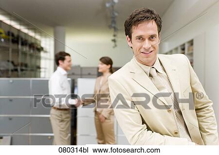 portrait of businessman with two colleagues shaking hands in the background View Large Photo Image Stock Image - portrait of businessman with two colleagues shaking hands in the background. Fotosearch