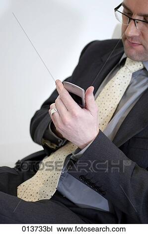 Stock Image - portrait of businessman writing text message on mobile phone. Fotosearch