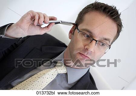 Stock Image - portrait of ceo sitting in chair listening to mobile. Fotosearch