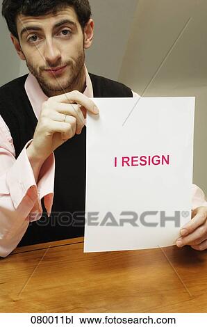 portrait of frustrated businessman sitting at desk holding resign document View Large Photo Image Stock Image - portrait of frustrated businessman sitting at desk holding resign document. Fotosearch