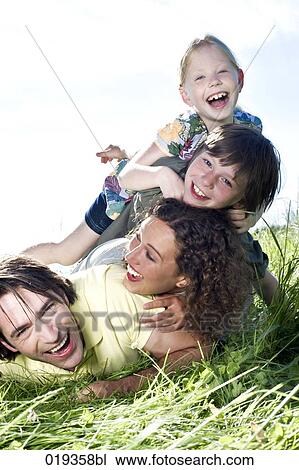portrait of happy family lying in grass View Large Photo Image Stock Image - portrait of happy family lying in grass. Fotosearch
