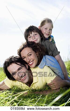portrait of happy family lying in grass View Large Photo Image Stock Image - portrait of happy family lying in grass. Fotosearch