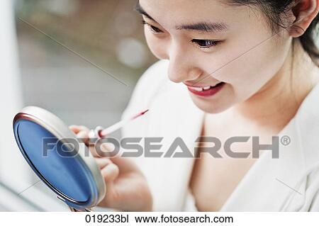 portrait of japanese girl applying lip-gloss View Large Photo Image Stock Image - portrait of japanese girl applying lip-gloss. Fotosearch