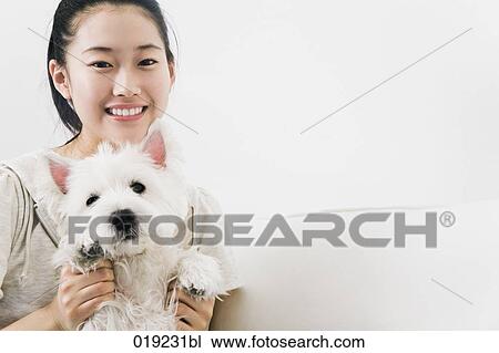 Stock Image - portrait of japanese girl with west highland terrier. Fotosearch