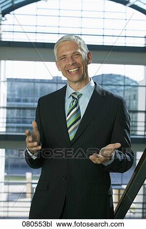Stock Image - portrait of mature businessman making inviting gesture. Fotosearch