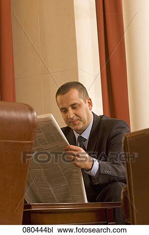 portrait of mature businessman sitting in hotel lobby reading newspaper View Large Photo Image Stock Image - portrait of mature businessman sitting in hotel lobby reading newspaper. Fotosearch