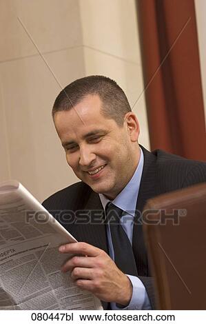 portrait of mature businessman sitting in hotel lobby reading newspaper View Large Photo Image Stock Image - portrait of mature businessman sitting in hotel lobby reading newspaper. Fotosearch
