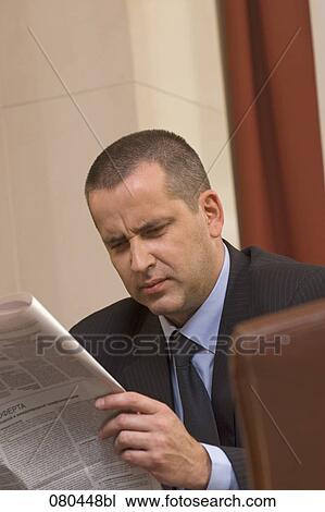 portrait of mature businessman sitting in hotel lobby reading newspaper View Large Photo Image Stock Image - portrait of mature businessman sitting in hotel lobby reading newspaper. Fotosearch
