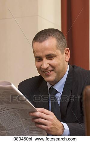portrait of mature businessman sitting in hotel lobby reading newspaper View Large Photo Image Stock Image - portrait of mature businessman sitting in hotel lobby reading newspaper. Fotosearch