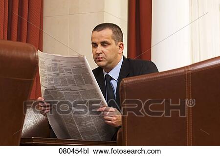portrait of mature businessman sitting in hotel lobby reading newspaper View Large Photo Image Stock Image - portrait of mature businessman sitting in hotel lobby reading newspaper. Fotosearch